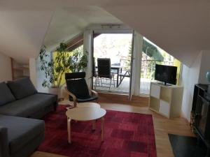 sala de estar con sofá, TV y mesa en Apartment Stasch, en Erlangen