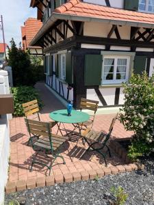 une terrasse avec une table et des chaises devant une maison dans l'établissement La clé du Temps, à Offendorf