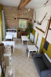 una sala con tavoli e sedie e una cucina di Domaine de l'île - Gîtes et chambres d'hôtes a Castelsarrasin