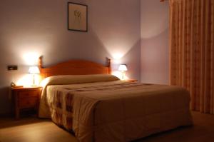 a bedroom with a bed and two lamps on tables at Hotel Los Duques in Béjar