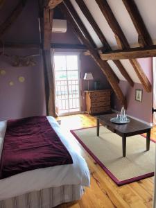 a bedroom with a bed and a table in a room at Cottage du vigneron in Vernou-sur-Brenne