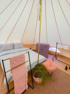 a bedroom in a tent with a bed in it at The Hunters Glamping in Ciudanoviţa