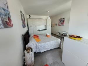 a small bedroom with a bed and a kitchen at Rosato 2 Sea View Apartment in Lignano Sabbiadoro +13 photos