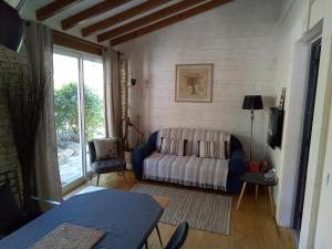 uma sala de estar com um sofá e uma janela em La chambre haute et son spa em Nîmes