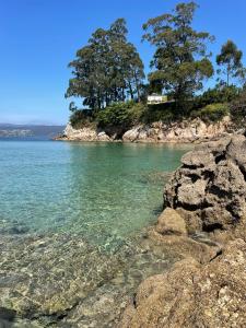 ein Haus auf einer felsigen Insel im Wasser in der Unterkunft O Porto Mariñeiro in Cillero