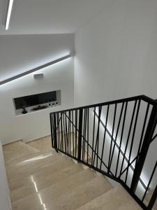 un escalier avec une rampe noire dans une pièce dans l'établissement Maestro - Rooms & Resturant, à Vukovar