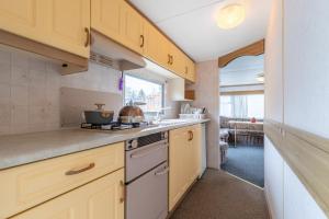 a kitchen with yellow cabinets and a stove top oven at Atokaita in Palanga
