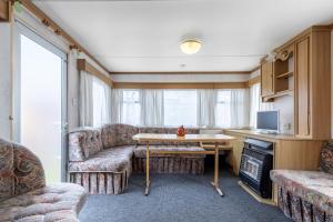 a living room with couches and a table and a tv at Atokaita in Palanga
