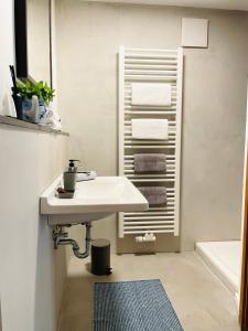 a white bathroom with a sink and a bath tub at Ferienwohnung am Elberadweg in Meißen