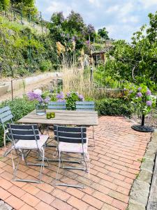 a patio with a table and two chairs and flowers at Ferienwohnung am Elberadweg in Meißen +9 photos