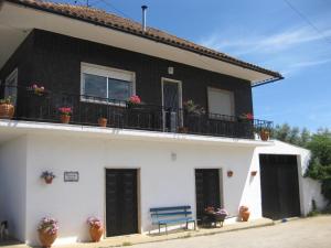 una casa en blanco y negro con un banco azul en Quinta dos Church, en Ansião