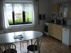 a kitchen with a table and a table and chairs at Apartmán U paní Věrky in Sloup