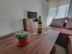 a table with a bottle of wine and two glasses at Apartments Chipsy in Herceg-Novi