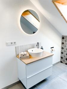 a bathroom with a sink and a mirror at TANTE IDA‘S in Lindau-Bodolz