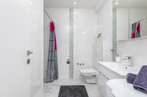 biała łazienka z umywalką i toaletą w obiekcie Apartman Knezevic A w Fažanie
