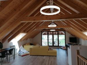a living room with wooden ceilings and a yellow couch at Casa Patxikuzuria in Espinal-Auzperri