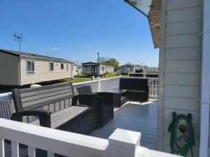 a balcony with two benches on a deck at 2BR-Sleeps6-Fireplace-Parking-Patio-Seaside in Clacton-on-Sea