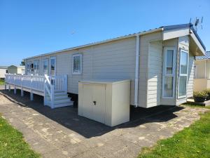 a mobile home with a porch and a door at 2BR-Sleeps6-Fireplace-Parking-Patio-Seaside in Clacton-on-Sea