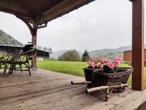 a patio with a basket of flowers on a deck at Domek na Berechu Domek w Górach-Pieniny in Szlachtowa