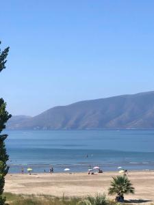 einen Strand mit Menschen und Sonnenschirmen im Wasser in der Unterkunft Riviera in Vlorë