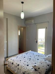 1 Schlafzimmer mit einem Bett mit Blumenbettdecke und einem Fenster in der Unterkunft Riviera in Vlorë