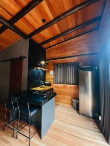 a kitchen with a counter and a refrigerator at Sentiero Cabanas Boutique in Urubici +86 photos