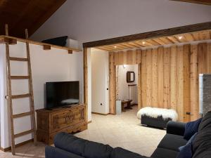 ein Wohnzimmer mit einem Sofa und einem Flachbild-TV in der Unterkunft Villetta Drena in Drena