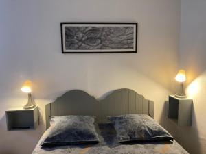 sypialnia z łóżkiem z dwoma światłami na ścianie w obiekcie Logisfontainebleau w mieście Villiers-sous-Grez