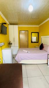 a bedroom with two beds and a yellow wall at Agnes Guest House in Germiston