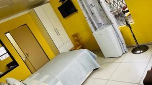 a bedroom with a bed and a yellow wall at Agnes Guest House in Germiston +33 photos