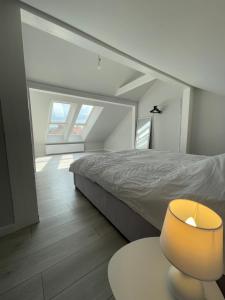 a bedroom with a bed and a lamp on a table at Apartament LuxLook in Nowy Sącz