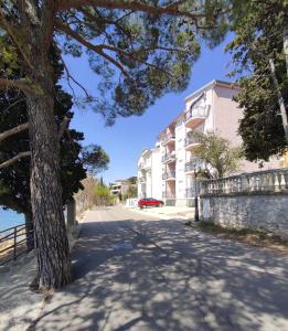 a tree on the side of a road next to a building at Apartment Lori in Crikvenica