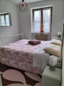 1 dormitorio con 1 cama grande con manta rosa en LA TORRETTA SUL LAGO di TENNO - RESIDENCE LA RUSTICA, en Tenno