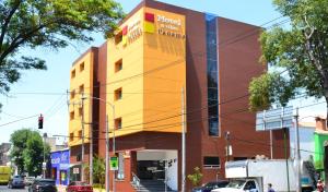 ein Gebäude in einer Stadtstraße mit parkenden Autos in der Unterkunft Hotel & Villas Panamá in Mexiko-Stadt