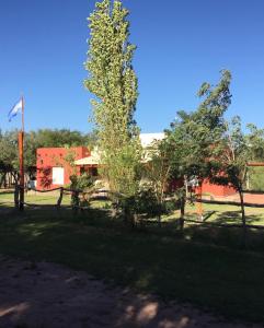 un parque con árboles y un edificio rojo en Cabaña Chañares de Banda Florida - Sveña en Villa Unión