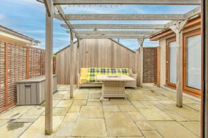 eine Terrasse mit einer Bank und einer Pergola in der Unterkunft 43 annexe in Newquay