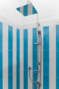 Łazienka z prysznicem wyłożona jest niebieskimi i białymi kafelkami. w obiekcie Blue Coral Suite B&B w Sorrento