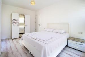 Un dormitorio blanco con una cama grande y un espejo. en DELUXE VİLLA Kuşadası, en Kusadasi 19 fotos más