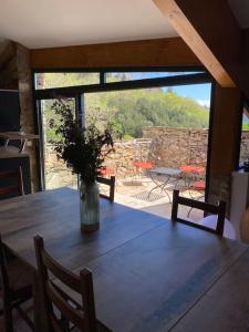 une table en bois avec un vase de fleurs. dans l'établissement La Bergerie, à Saint-Vincent