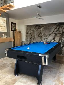 a blue pool table in a room with a wall at La Bergerie in Saint-Vincent