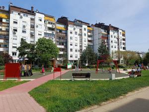 um parque com parque infantil em frente a edifícios altos em Serbian home - 44 em Bežanija