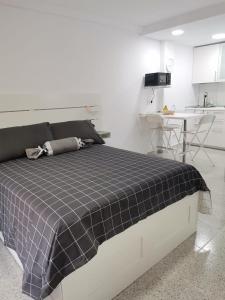 um quarto com uma cama com um cobertor xadrez azul em Anatolia playa Jardin PUERTO DE LA CRUZ Estudio em Puerto de la Cruz