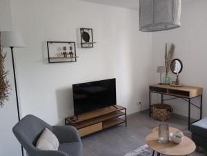 ein Wohnzimmer mit einem TV, einem Sofa und einem Tisch in der Unterkunft Provizial Ferienwohnung Rudi in Wadgassen