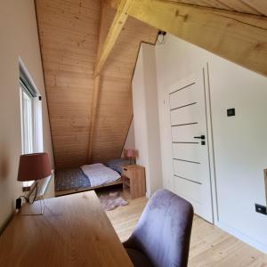 an attic room with a bed and a table at Domki Wzgórze Kamień in Józefów +29 photos