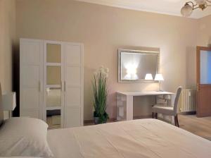 1 dormitorio con cama, escritorio y espejo en Appartamento Romeo, nel cuore di Roma, en Roma