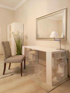 escritorio blanco con silla y espejo en Appartamento Romeo, nel cuore di Roma, en Roma
