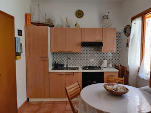 a kitchen with wooden cabinets and a table with a bowl on it at Makari mare in Macari