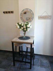 a table with a vase of flowers and two stools at Séjour à la campagne in Bouhy