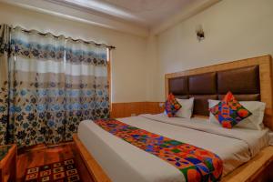 Un dormitorio con una cama grande y una ventana en Hotel Rockland Inn, en Manali