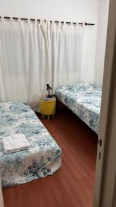 2 camas en una habitación con cortinas blancas en Lujoso Dpto en Zona Norte en Salta